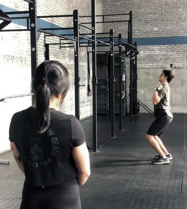 Picture of Michelle coaching a CrossFit athlete at the gym
